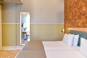 a bedroom with a large bed and a mirror at My Story Hotel Tejo in Lisbon