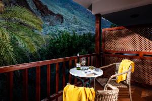 a table and chairs on a balcony with a mountain view at Parador de El Hierro in Las Casas