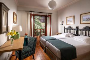 a bedroom with a bed and a desk and a chair at Parador de El Hierro in Las Casas