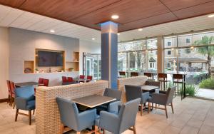 a restaurant with tables and chairs and windows at Holiday Inn Express & Suites - Gainesville I-75, an IHG Hotel in Gainesville