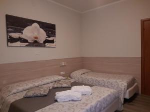 a hotel room with two beds and a flower on the wall at Albergo Paradiso in Maccagno Superiore