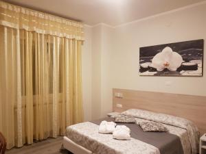 a bedroom with two beds and a flower on the wall at Albergo Paradiso in Maccagno Superiore