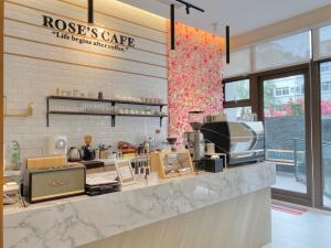 Champ De Rose Hotel في مدينة هوالين: a coffee shop with a counter with aasteryasteryasteryasteryasteryasteryastry