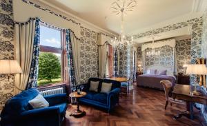 um quarto com uma cama e um sofá azul em Cahernane House Hotel em Killarney