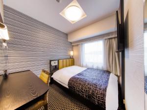 a hotel room with a bed and a window at APA Hotel Hiroshima Ekimae Ohashi in Hiroshima