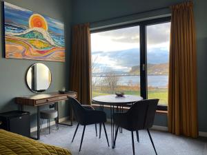 um quarto com uma mesa e cadeiras e uma grande janela em Stones Luxury B&B with hot tub and self-contained rooms em Uig