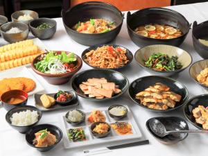 a table with many bowls of food on it at APA Hotel Hiroshima Ekimae Ohashi in Hiroshima