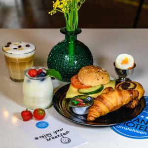 een tafel met een bord eten en drinken bij Grand Hotel Amstelveen in Amstelveen