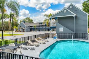 a swimming pool with chairs and a building at GatorTown Inn in Gainesville