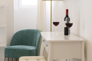 a bottle of wine and two glasses on a table at Suites Amália Guesthouse near Rossio Square in Lisbon