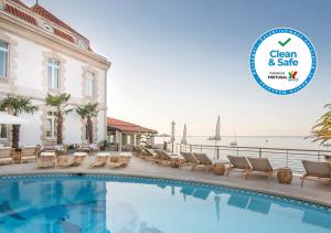 ein Swimmingpool in einem Hotel mit einem Schild, auf dem sauber und sicher steht in der Unterkunft The Albatroz Hotel in Cascais