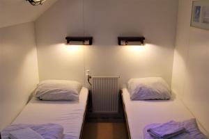 two beds in a small room with lights on the wall at Felicitas in Amsterdam