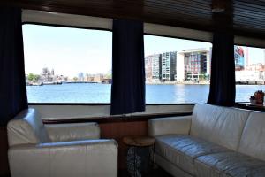 two couches in a room with a view of the water at AmicitiA in Amsterdam