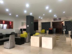 a lobby with colorful chairs and tables in a building at We Hotel Aeropuerto in Mexico City