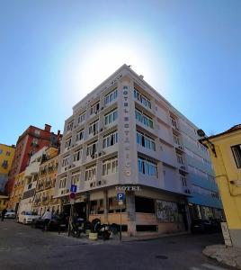 a large white building on the corner of a street at Hotel Botanico in Lisbon