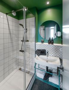 a bathroom with a sink and a shower at Hôtel Tandem - Boutique Hôtel in Strasbourg