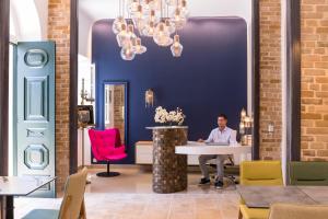 a man sitting at a table in a room with a blue wall at Acanthus blue in Corfu