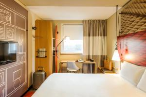 Un pat sau paturi într-o cameră la ibis Hotel Muenchen City West