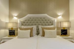 a white bed with pillows and two lamps at Villa Mariazinha Charming Hotel in Portimão