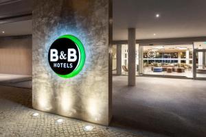 a large lobby with a bbb hotel sign on a wall at B&B HOTEL Lisboa Aeroporto in Lisbon