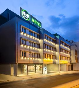 a hotel with a lit up facade at night at B&B HOTEL Lisboa Aeroporto in Lisbon