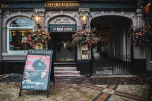 un leone rosso con un cartello davanti di OYO The Red Lion Hotel a Luton