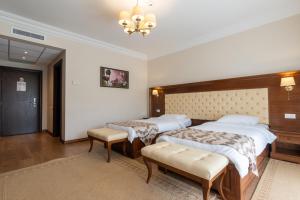 a hotel room with two beds and a chandelier at Hotel Gabriela in Vişeu de Sus