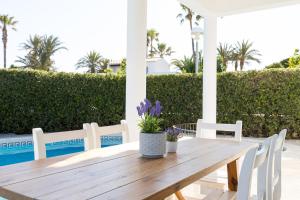 a wooden table and chairs on a patio at Chalet a 150m de la playa y piscina privada in Cala'n Bosch