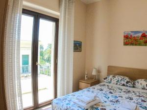 a bedroom with a bed and a sliding glass door at La Casa di Aurora in Reggio di Calabria