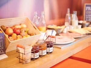 ein Buffet mit Äpfeln und Marmeladen auf dem Tisch in der Unterkunft ibis Lyon Gerland Musée des Confluences in Lyon