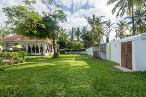 um quintal em frente a um edifício com palmeiras em Villa Ameera Malindi em Melinde