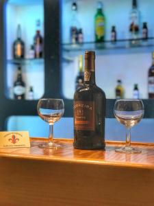 a bottle of wine and two glasses on a bar at Pensao Residencial Flor dos Cavaleiros in Lisbon