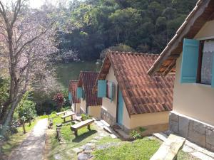 una fila de edificios con un banco en el patio en Pousada dos Anjos, en São Pedro da Serra