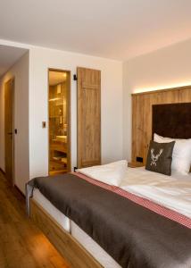 a bedroom with a large bed with a wooden headboard at Steig-Alm Hotel Superior in Bad Marienberg