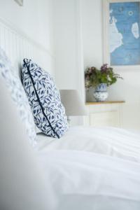 a white bed with two pillows on top of it at Hotel Villa Brinkly in Snekkersten