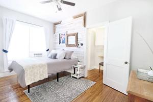 a white bedroom with a bed and a ceiling fan at Dallas Native, Lower-Greenville Ave Area in Dallas