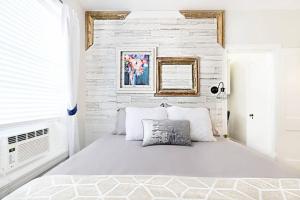 a white bedroom with a white brick wall at Dallas Native, Lower-Greenville Ave Area in Dallas