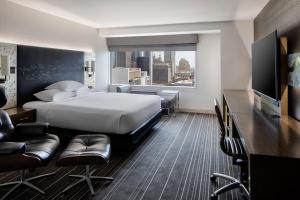 een hotelkamer met een bed, een bureau en stoelen bij Hyatt Regency Dallas in Dallas