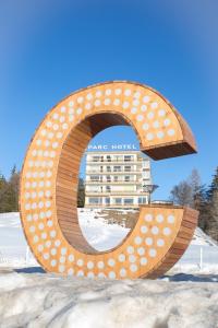 een groot metalen bord met een hotel op de achtergrond bij Grand Hôtel du Parc in Crans-Montana