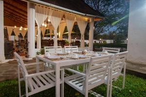 uma mesa branca e cadeiras em frente a um edifício em Villa Ameera Malindi em Melinde