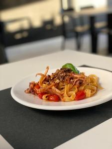 a plate of pasta with meat and vegetables on a table at Hotel Continental in Reggio di Calabria