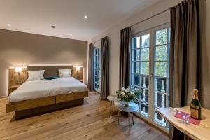 a bedroom with a bed and large windows at Château de Pourtalès in Strasbourg