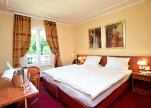 a hotel room with a large bed and a window at Château de Pourtalès in Strasbourg