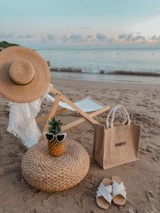 słomiany kapelusz i kosz z ananasem na plaży w obiekcie Kenting Sunhow Inn w Kenting