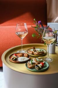 a tray with three plates of food and a glass of wine at Okko Hotels Strasbourg Centre in Strasbourg