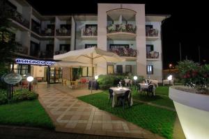 een hotelpatio met tafels en parasols in de nacht bij Hotel Eden in Valeggio sul Mincio