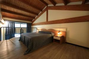 een slaapkamer met een bed in een kamer met houten plafonds bij Hotel Eden in Valeggio sul Mincio