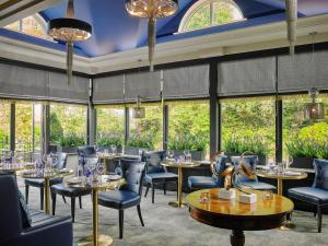 a restaurant with tables and chairs and large windows at Killarney Randles Hotel in Killarney