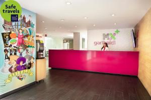 a woman standing behind a pink counter in a store at Hotel MX garibaldi in Mexico City