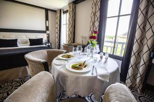 - une salle à manger avec une table, des chaises et un lit dans l'établissement Jehan De Beauce - Teritoria, à Chartres